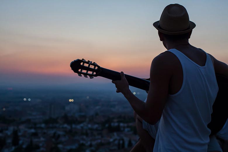 Mężczyzna grający łatwą hiszpańską piosenkę na gitarze