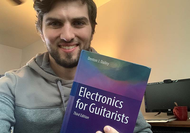 Me holding my copy of Electronics for Guitarists